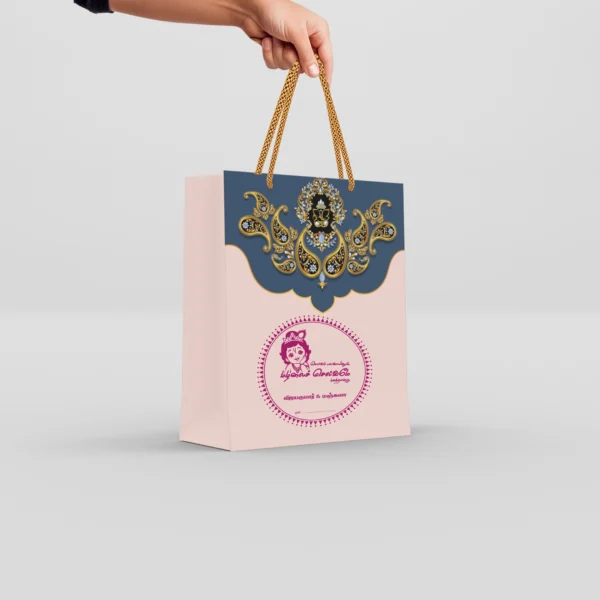 Customized thamboolam bags in blush pink and royal blue with jeweled Ganesha artwork and braided gold rope handle.