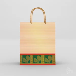 Cream thamboolam paper bag with emerald green peacock zari border and braided gold rope handle against a plain background